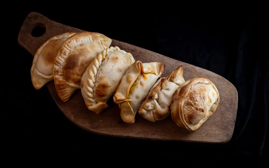 Deliciosas empanadas caseras servidas en una tabla de madera, que muestran la cocina tradicional argentina.